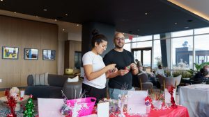 Two residents participate in an event inside Hudson House's lounge